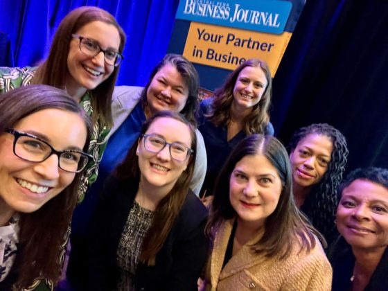 A selfie photo of 8 women smiling at the camera.