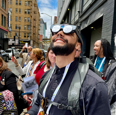 A picture of a man looking up to the sky, participating in an augmented reality tour.