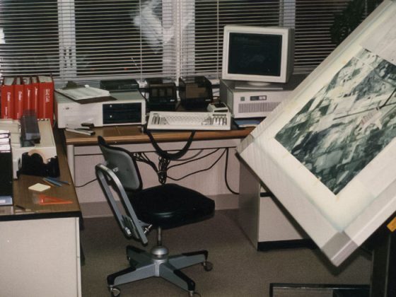 GeoDecisions’ first office space in 1988 with an old map/drawing table, chair, and various office equipment.