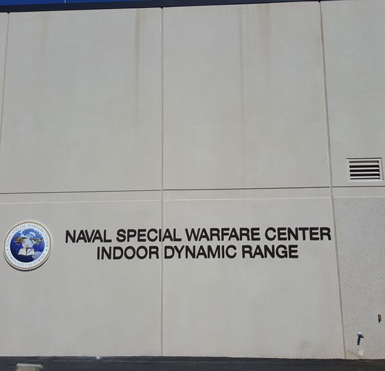 Concrete exterior of building with signage that reads “Naval Special Warfare Center Indoor Dynamic Range.”