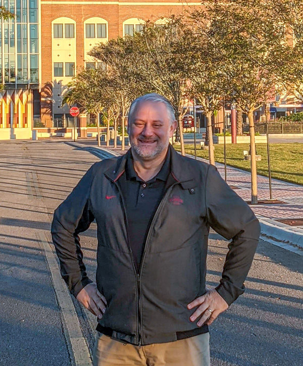 Eric Abrams, senior project manager, stands in front of the Florida State University Doak Campbell Stadium on a fall day.