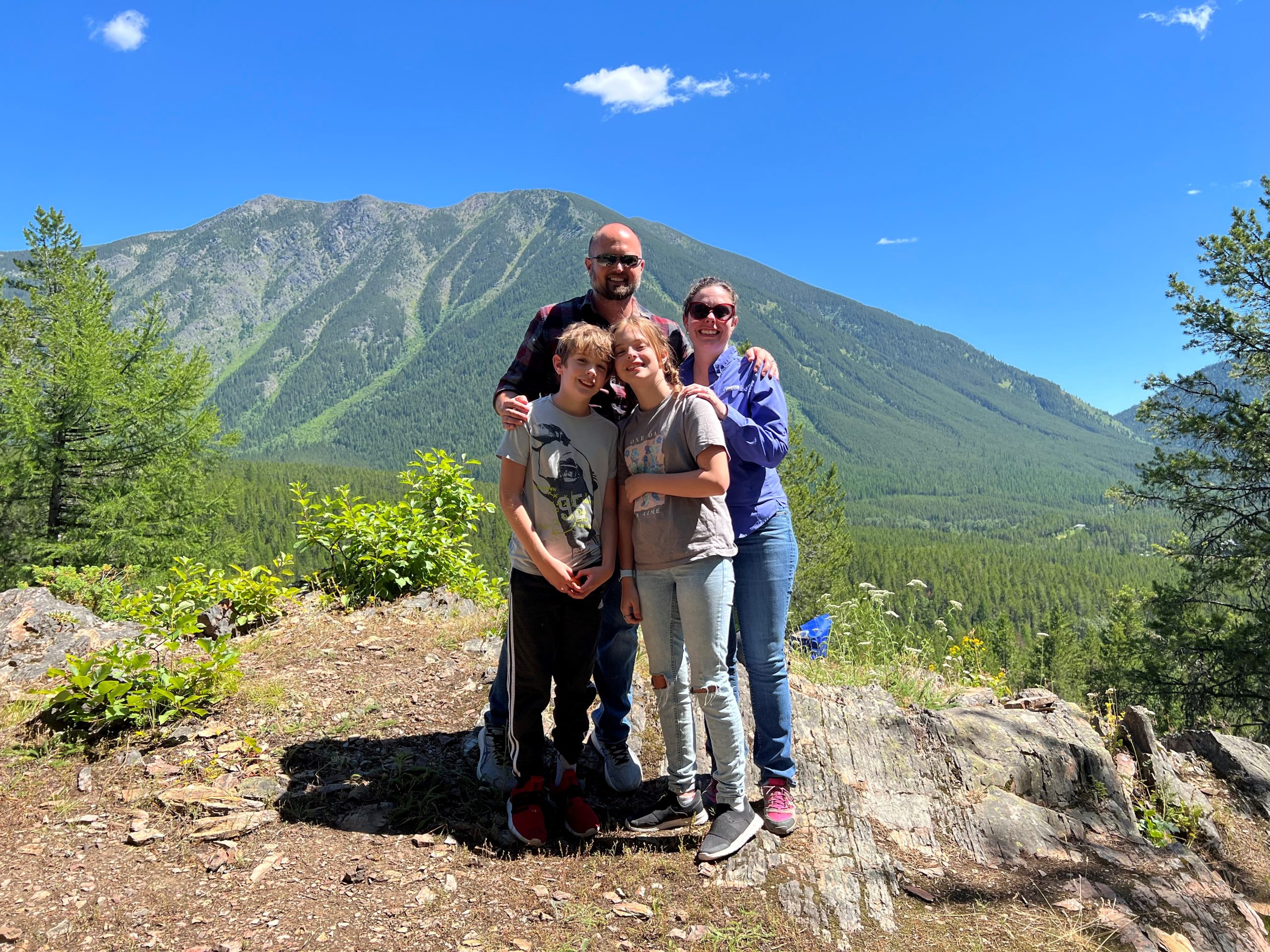 A man, a woman, and two children stand together in Glacier National Park.