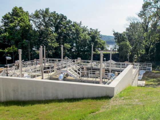 Wastewater treatment infrastructure sits on a steeply graded slope.