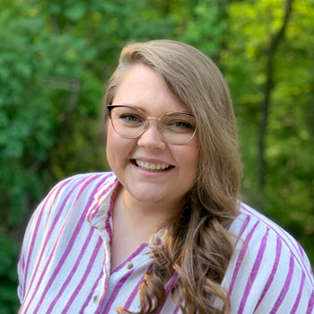 Heather Wilkie, Associate Business Analyst, standing outside.