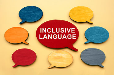 Different colored speech bubbles with one large one in the middle of the photo that says, “Inclusive Language.”