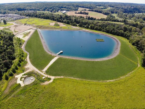 Aerial view of the filled impoundment in rolling, wooded landscape.