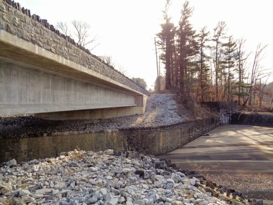 A new roadway bridge above a spillway and reservoir.