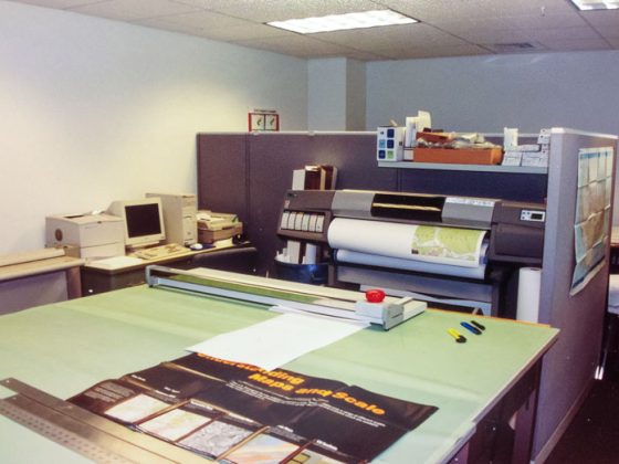 A GeoDecisions office located in State College, Pennsylvania, in 1996, including a big plotter printer, a desktop computer, and a large worktop table.