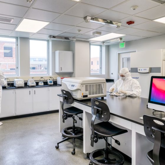 Two scientists in PPE working in Penn State University’s Ancient Biomolecules Research Laboratory.