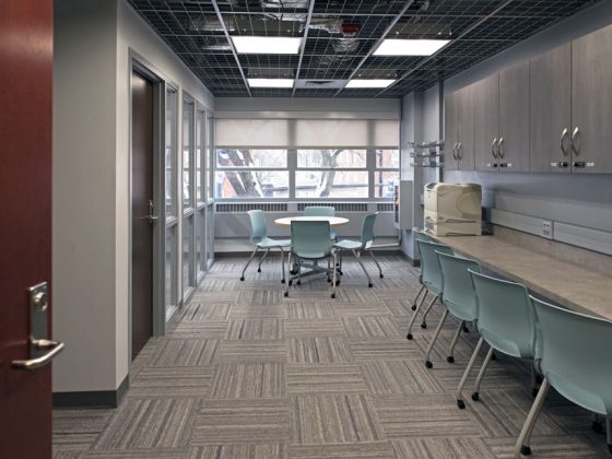 Workroom with counters, a table, chairs, and locking cabinets.