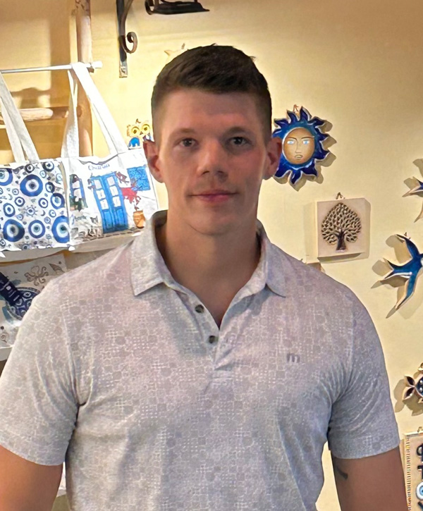 A man standing in front of a store wall.