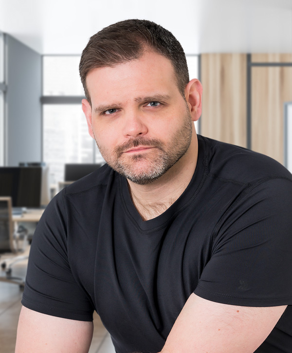 Joshua looks at the camera wearing a black t-shirt.