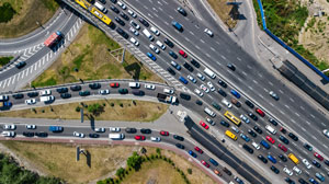 An overhead photograph of a congested highway with multiple vehicles attempting to merge